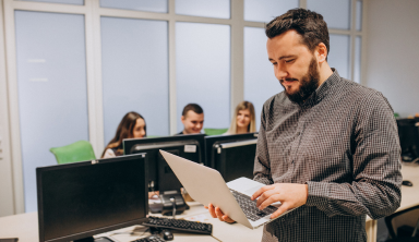 Onsite IT engineers collaborating with laptops and networking tools in a tech workspace.